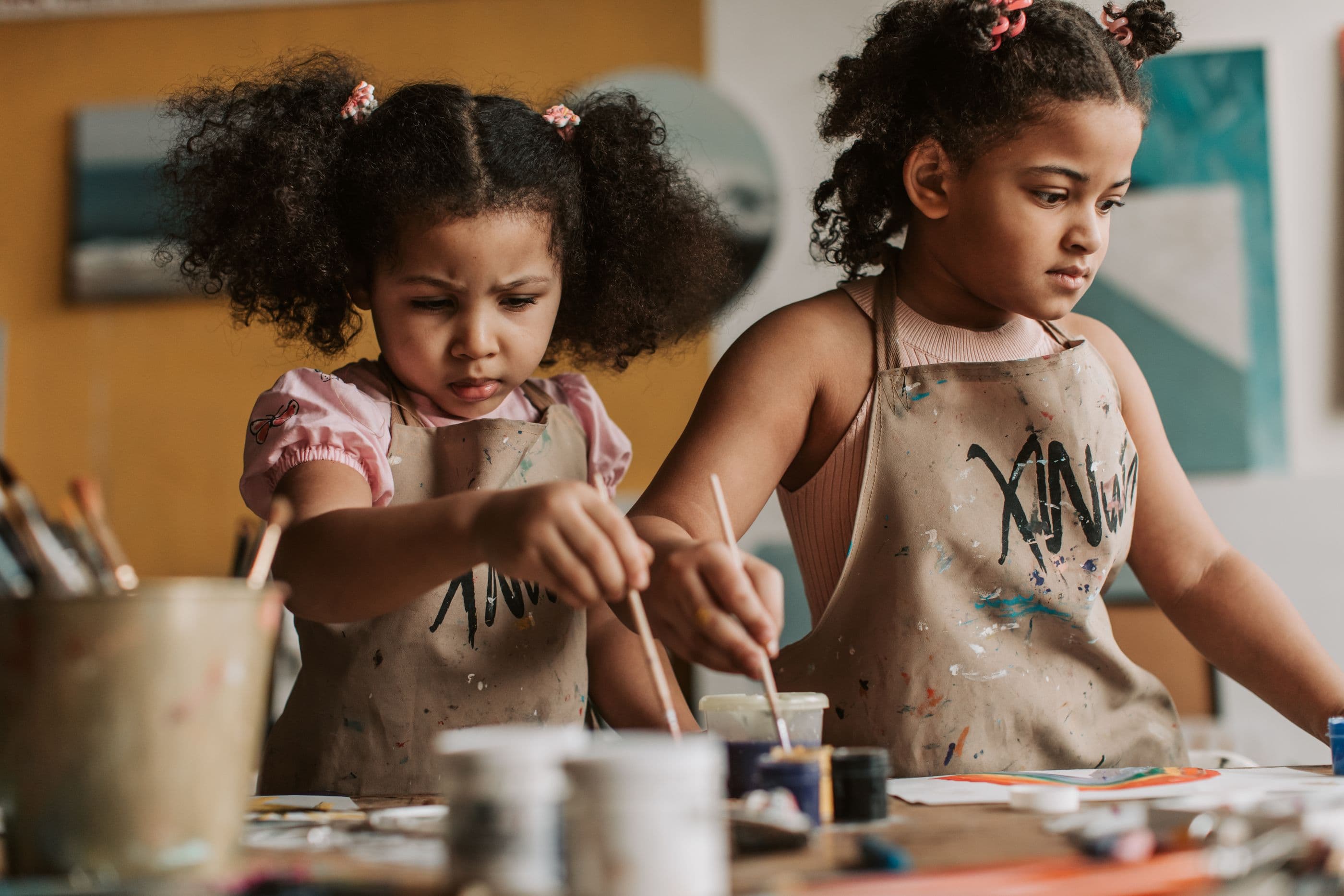 Project time: two children painting, absorbed in the work.